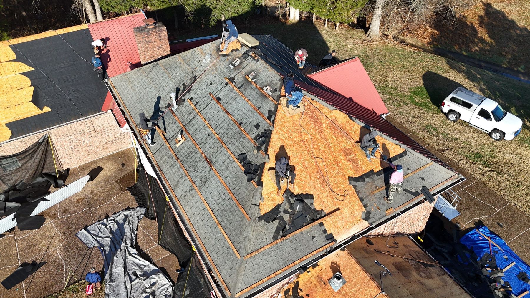 Drone view of a large crew tearing an old roof off down to the decking in Middle Tennessee